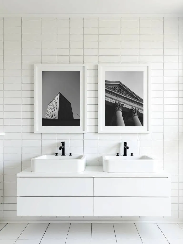 A minimalist bathroom with monochrome architectural photographs above the countertop.