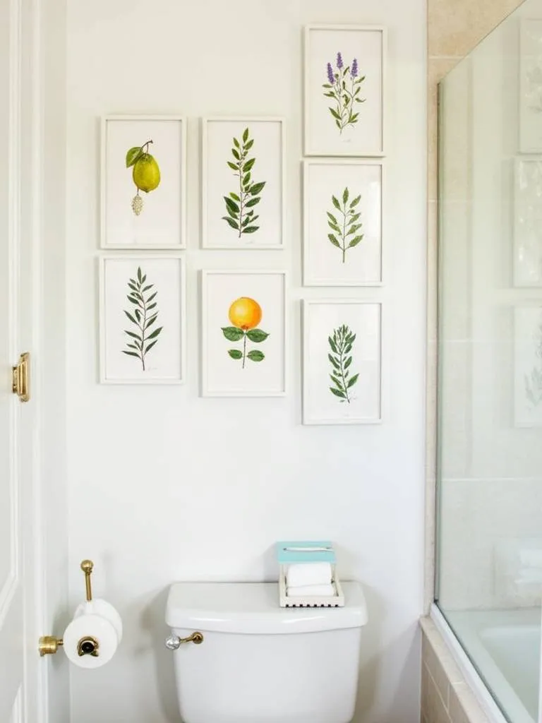 A gallery wall in a bathroom featuring framed botanical prints of Mediterranean plants like citrus, olive branches, and lavender.