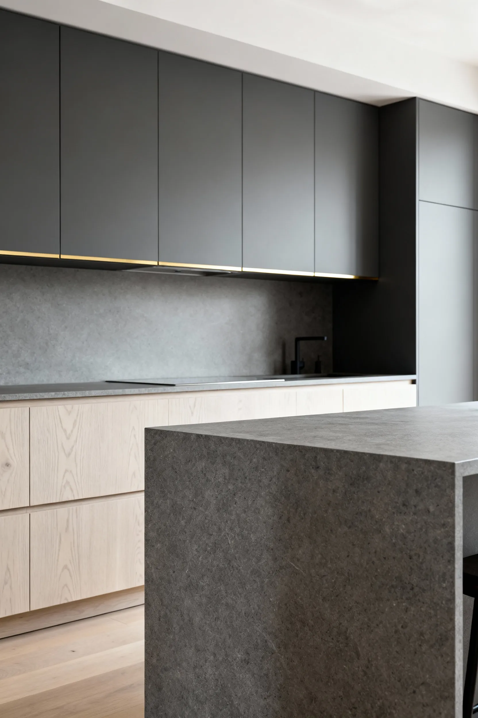Modern luxury kitchen featuring a blend of rift-sawn white oak, matte charcoal lacquer, and a honed Grigio Basaltina island, demonstrating sophisticated kitchen cabinet material harmonization.