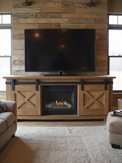 Rustic living room featuring a distressed wood TV console with sliding barn doors and exposed metal hardware, centered below a wall-mounted television.